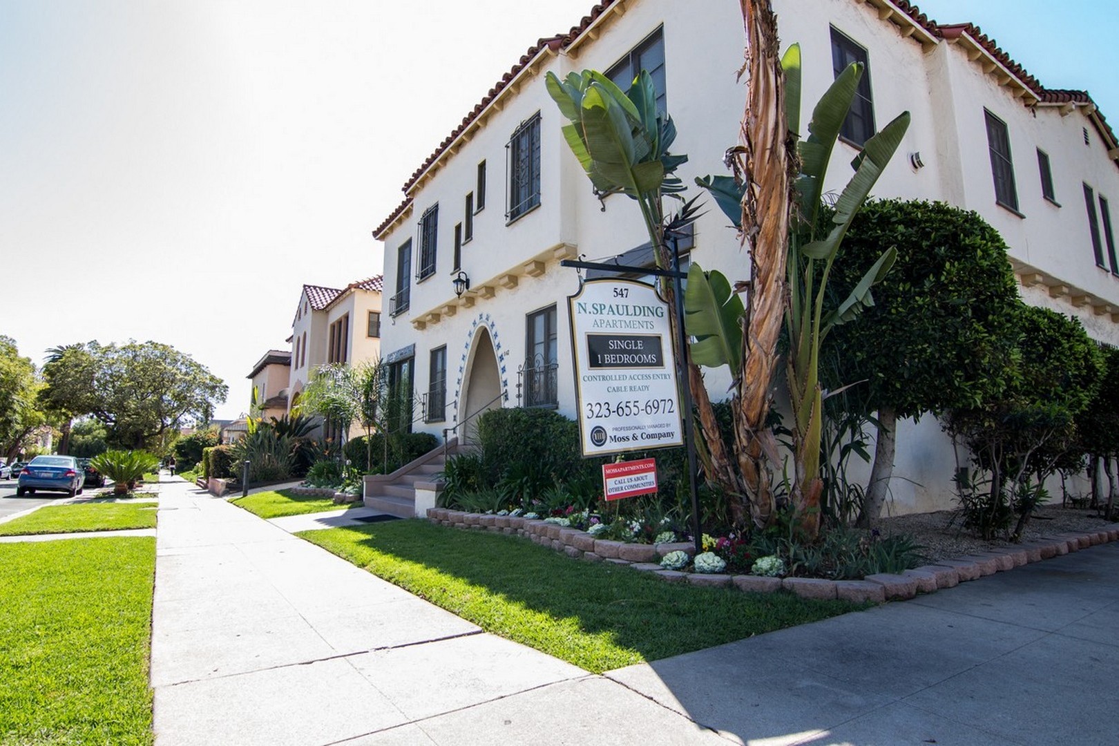 A sign for S.P.Aulding Estate Agents is in front of a white building.